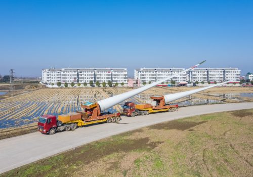 wind turbine blades on truck by rural road